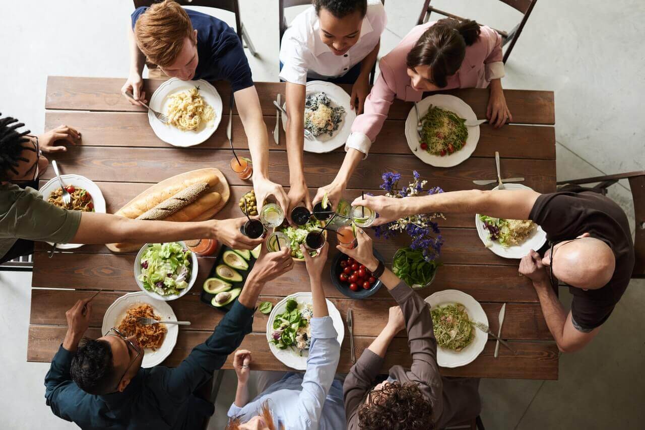 A group of people making a toast over a dinner table.