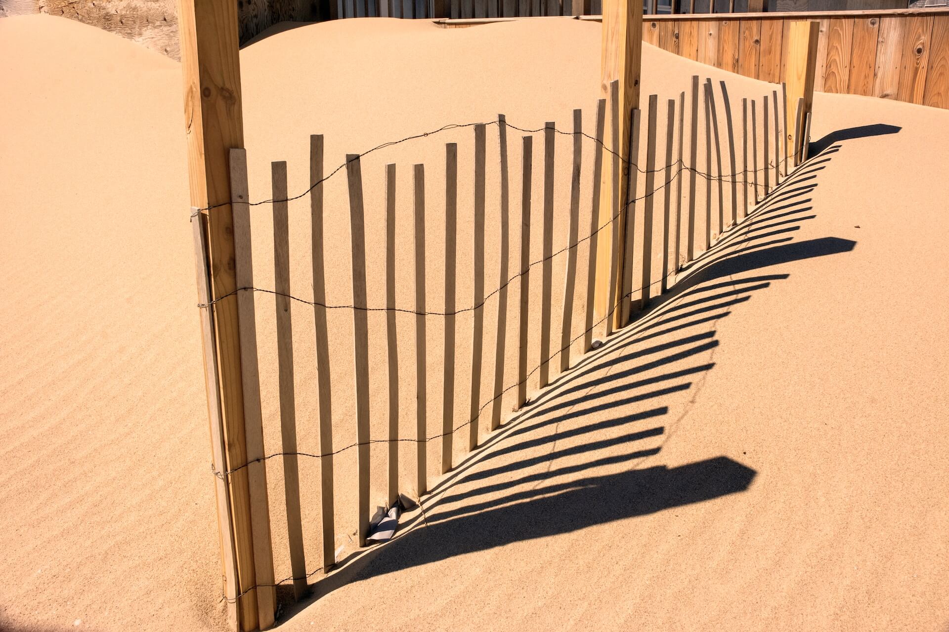 Simple wood fence on a sandy beach for Cape Cod catering.